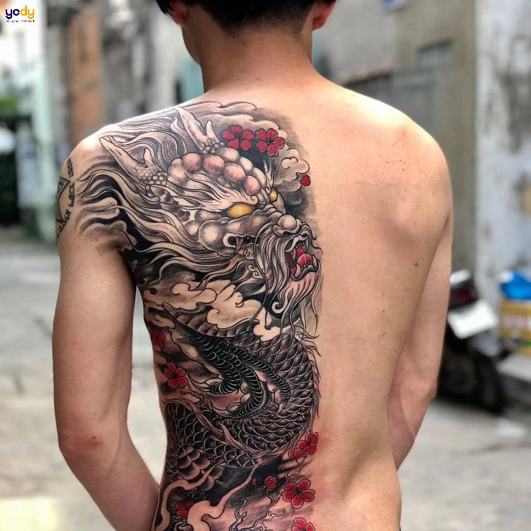 Nghệ sĩ đang thực hiện hình xăm nửa lưng phức tạp